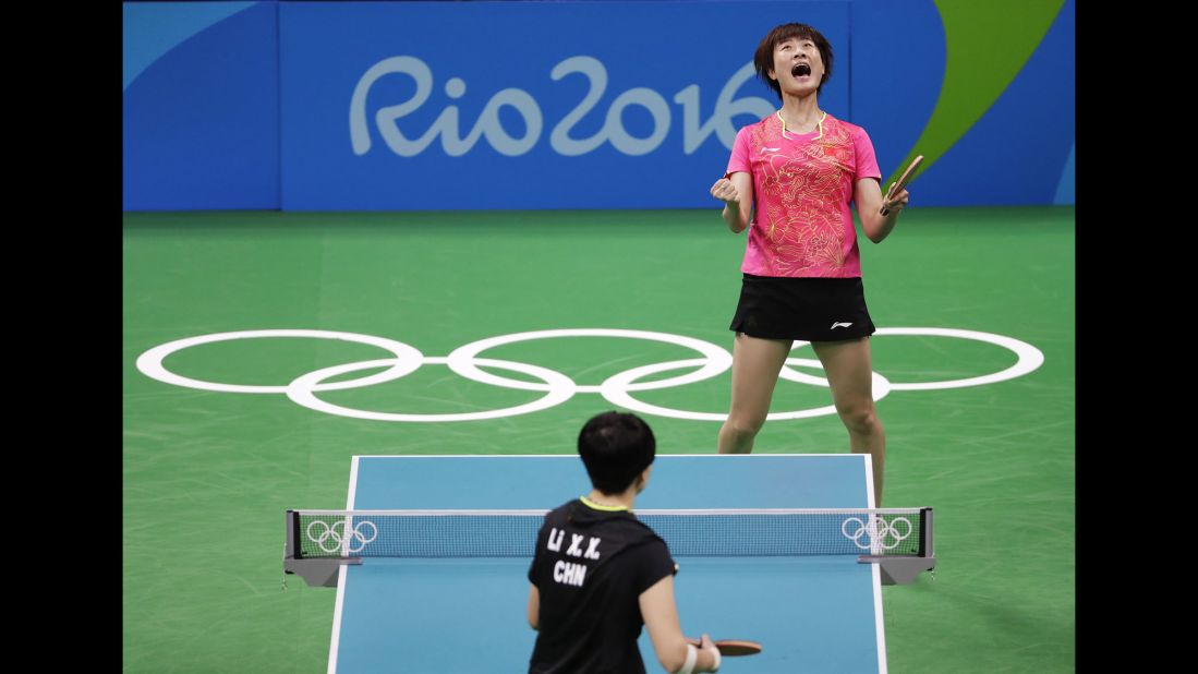 China's Ding Ning, top, reacts after defeating her compatriot Li Xiaoxia to win table tennis gold.