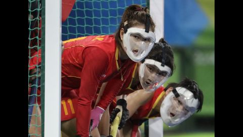 Chinese field hockey players wear protective face masks as they wait for a corner shot from the Netherlands.