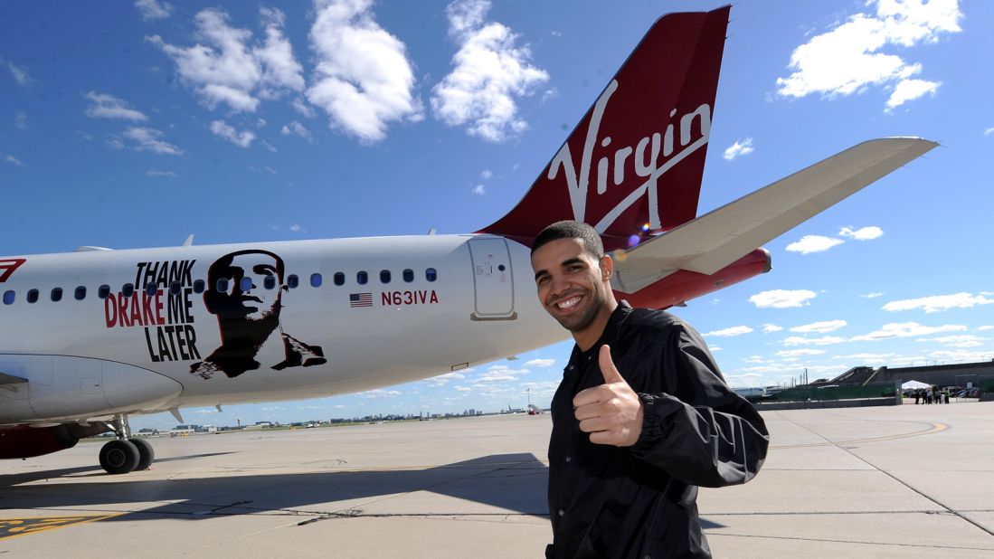 Virgin America has named several planes after celebrities. Pictured in 2010, Canadian R&B star Drake poses in front of Air Drake, which was named to celebrate Virgin America's first international flight to Toronto. <br />