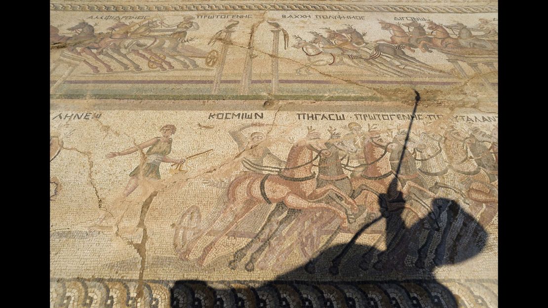 Fryni Hadjichristofi's shadow falls over the mosaic floor, depicting scenes from an ancient chariot race.