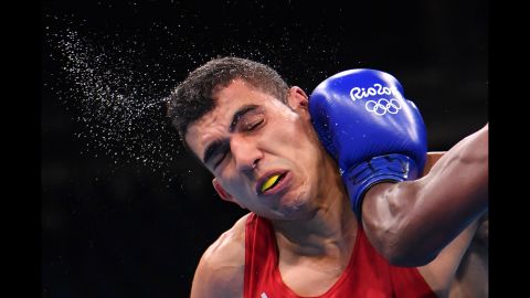 Morocco's Mohammed Rabii is punched by Kenya's Rayton Okwiri during their welterweight bout. Rabii advanced to the quarterfinals.