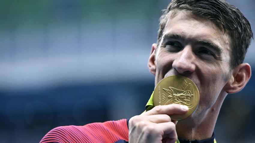 USA's Michael Phelps celebrates with his gold medal during the podium ceremony for the Men's 4x200m Freestyle Relay Final at the Rio 2016 Olympic Games on August 9.