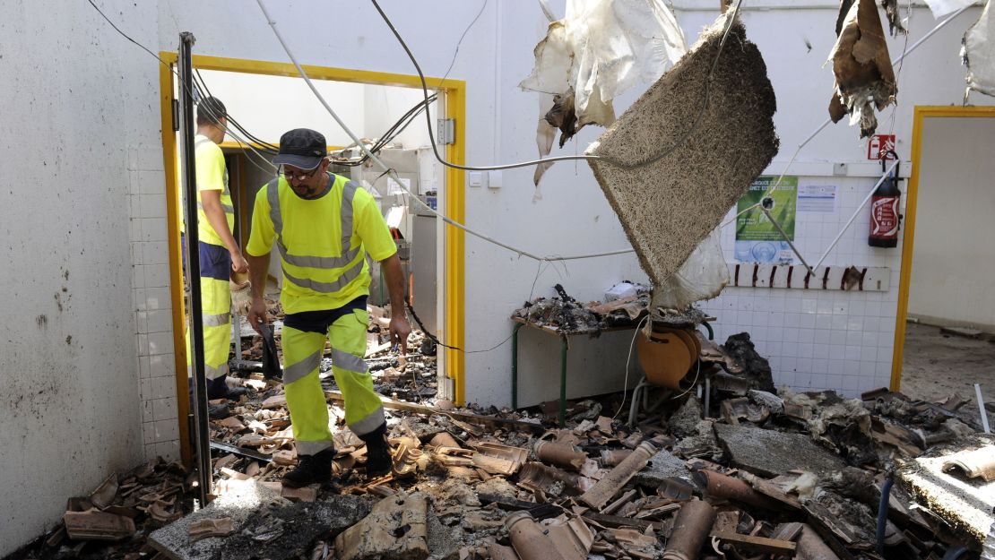 A man walks among the ruins of an elementary school burnt down in Vitrolles, France.