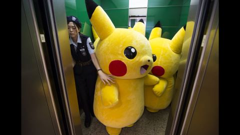 <strong>August 7:</strong> Performers dressed as Pikachu, a character from the Pokemon franchise, ride an elevator during the "Pikachu Outbreak" event in Yokohama, Japan. Hundreds of Pikachus were appearing at city landmarks to attract visitors in the Minato Mirai area.