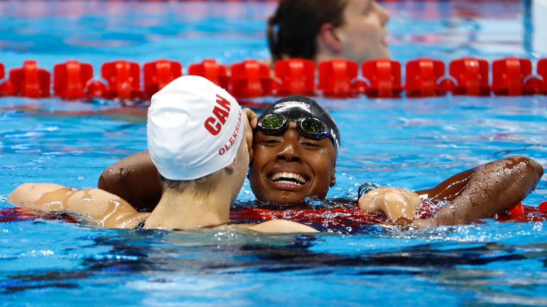 American Simone Manuel embraces Penny Oleksiak of Canada after the pair tied to win gold in the Women's 100m freestyle final on Day 6 of the Rio 2016 Olympic Games this August.