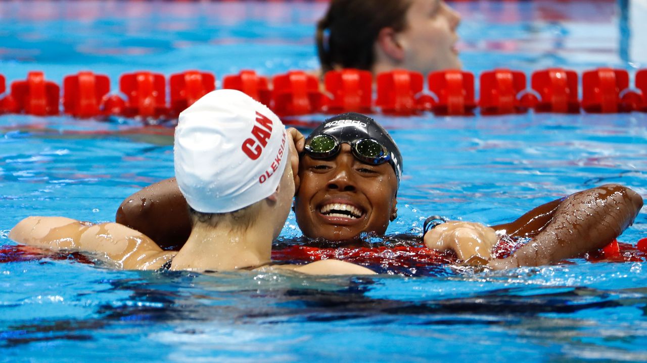 U.S. swimmer Simone Manuel, right, hugs Canadian Penny Oleksiak after they tied for first place in the 100-meter freestyle. They finished in an Olympic-record time of 52.70 seconds. Manuel is the first African-American woman to medal in an individual swimming event.