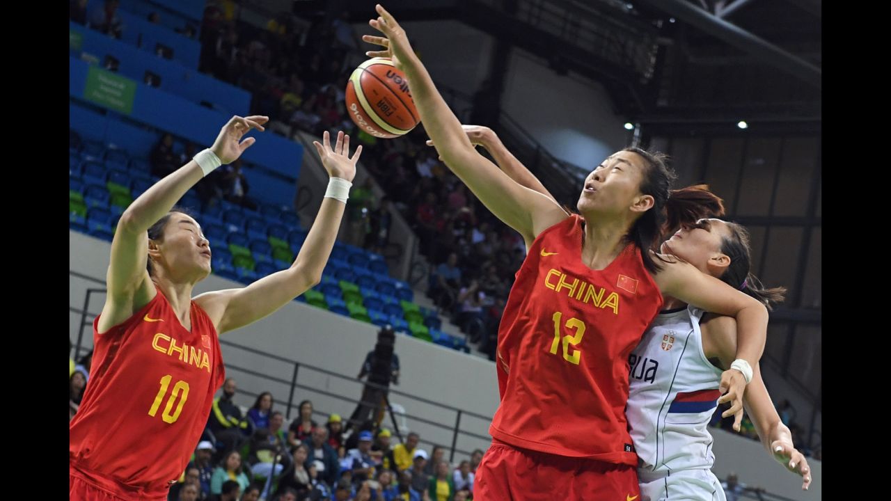 China's Lu Wen, left, and Gao Song compete for a rebound with Serbia's Sonja Petrovic.