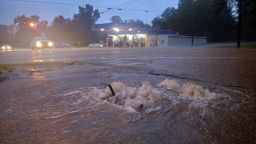 Floodwaters surge from a crack in the parking lot on the corner of highways 584 and 51 in Osyka, Miss., early Friday, Aug. 12, 2016. Flooding is also affecting areas of southwest Mississippi just north of the Louisiana state line.  (Matt Williamson/Enterprise-Journal via AP