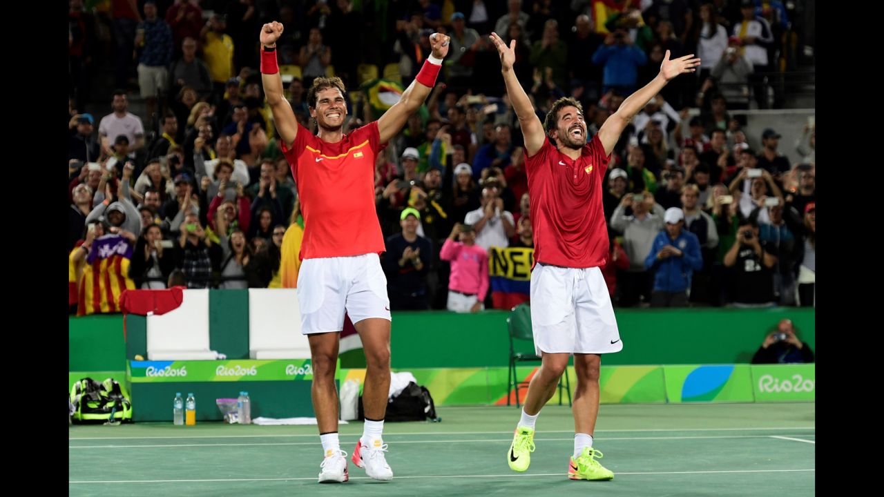 Spanish tennis players Rafael Nadal, left, and Marc Lopez acknowledge the crowd after winning gold in doubles. Nadal won singles gold in 2008.