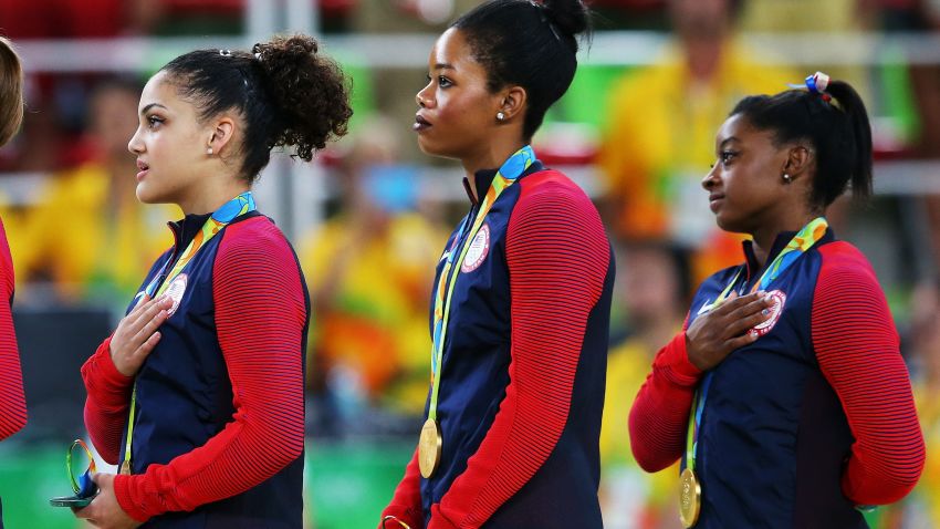 RIO DE JANEIRO, BRAZIL - AUGUST 09:  (R to L) Gold Medalists Simone Biles, Gabrielle Douglas, Lauren Hernandez, Madison Kocian and Alexandra Raisman of the United States stand on the podium for the national anthem at the medal ceremony for the Artistic Gymnastics Women's Team Final on Day 4 of the Rio 2016 Olympic Games at the Rio Olympic Arena on August 9, 2016 in Rio de Janeiro, Brazil.  (Photo by Alex Livesey/Getty Images)