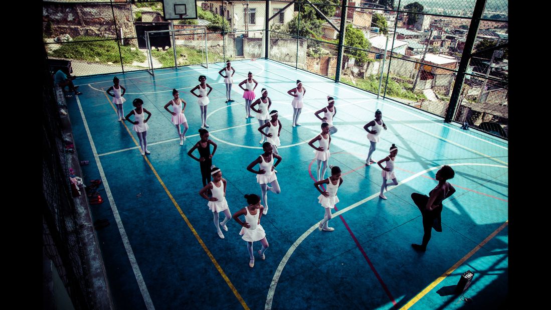 The ballet students practice on a basketball court.