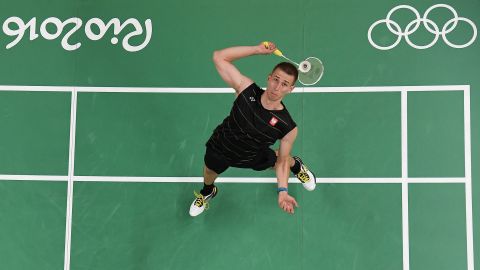 Poland's Adrian Dziolko serves to China's Chen Long during their singles qualifying badminton match.