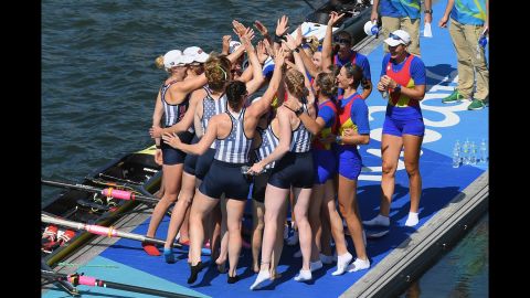 Team USA celebrates winning the gold with members of Romania's team, who won the bronze, in the women's eight rowing competition.