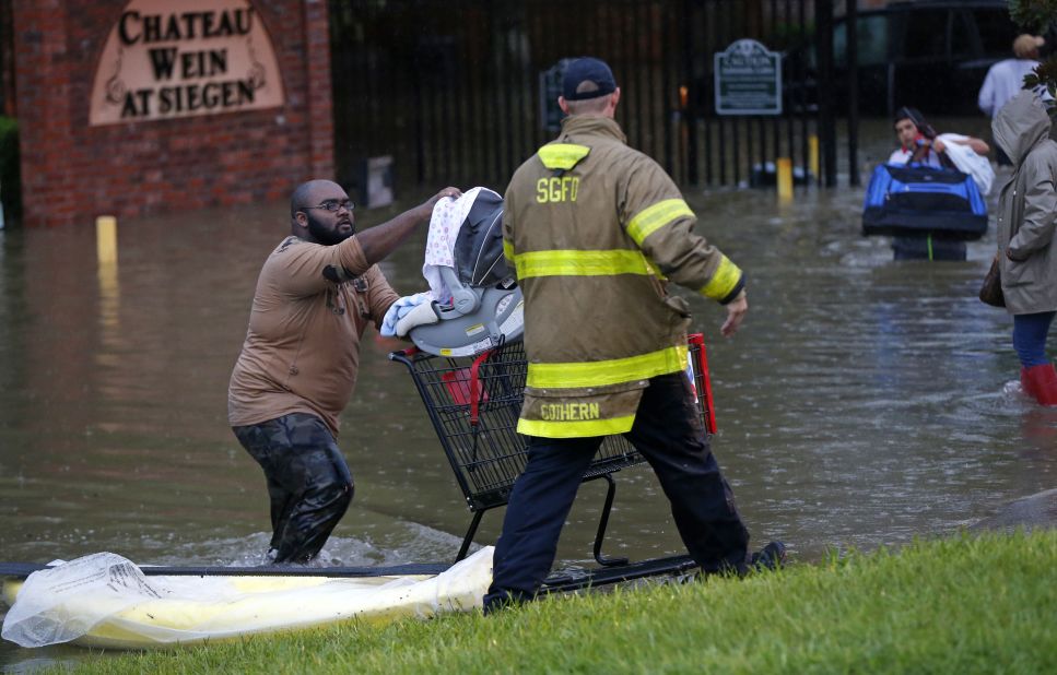 A firefighter helps a resident in Baton Rouge on Friday, August 12.