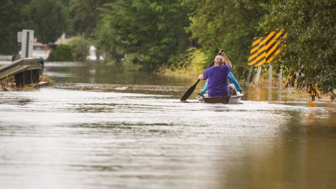 Jeremy and Chelsea LeMieux paddle through floodwaters in Carencro on August 13.