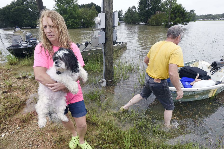 Tammie Wise holds her dog, Mikey, after Jeffrey Lesage helped rescue them in Central, Louisiana, on August 13.