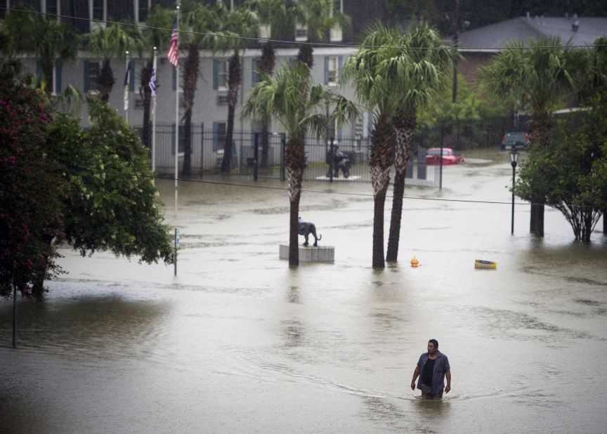 A resident wades through floodwaters at apartments near Louisiana State University in Baton Rouge.