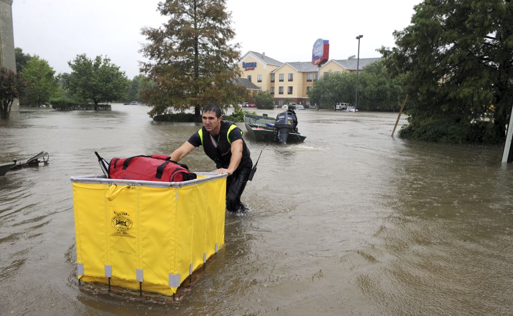 A firefighter brings luggage to hotel guests during an evacuation of the Fairfield Inn in Lafayette, Louisiana, on August 13.