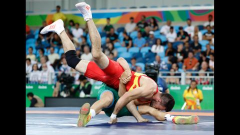Colombia's Carlos Andres Munoz Jaramillo, in red, is pulled to the ground by Hungary's Peter Bacsi in their men's 75kg greco-roman qualification match during the wrestling event.