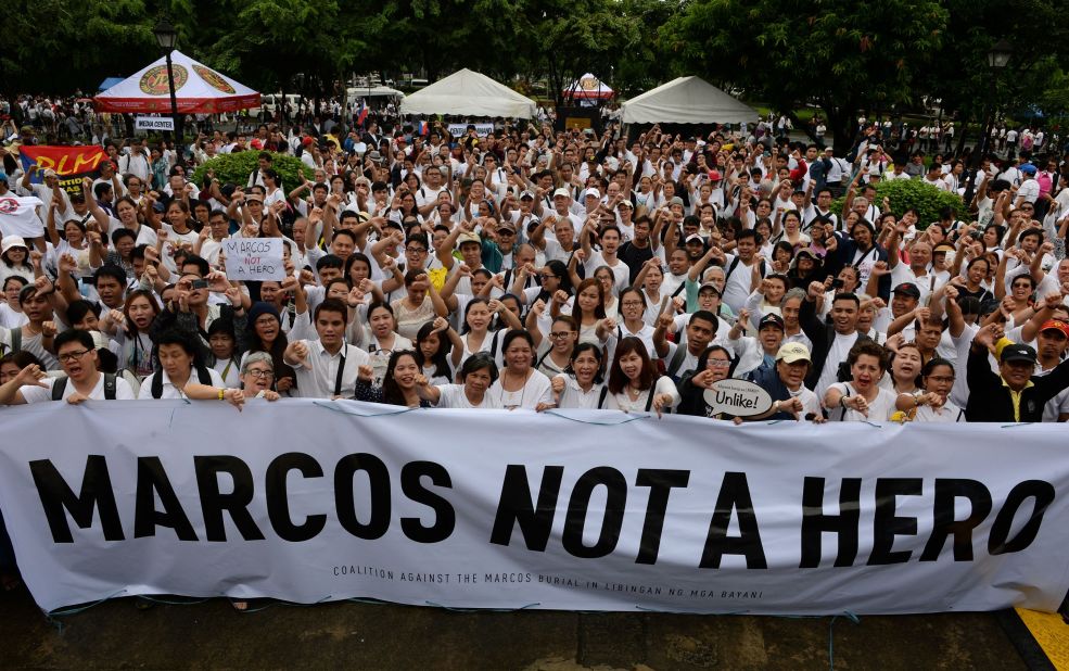 Protesters display placards with anti-Marcos slogans during a demonstration at a park in Manila on Sunday, August 14, 2016, against plans to honor the late dictator Ferdinand Marcos with a state burial.