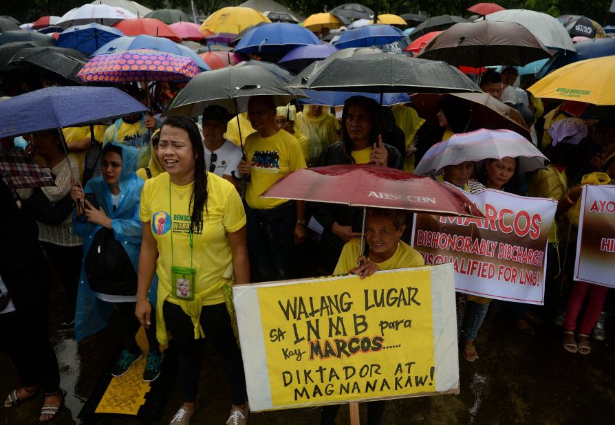 People braved the heavy but intermittent showers to voice their outrage over the decision to move the former dictator's body. Marcos ruled with an iron fist for two-and-a-half decades, and is accused of widespread corruption, overseeing torture and killings. 