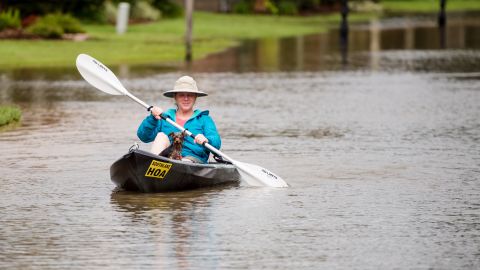 Jennifer Bernard and her dog, Shelby, travel by kayak down the flooded streets of Youngsville on August 14.