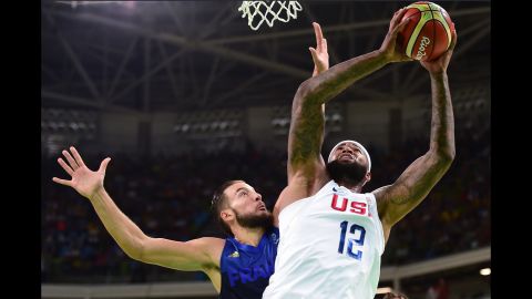Demarcus Cousins, right, shoots against Joffrey Lauvergne of France during a men's preliminary round Group A basketball game, which the US won 100-97.