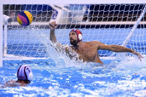 US goalie Merrill Moses saves a shot against Italy during in a men's water polo preliminary round match. The Americans won 10-7.