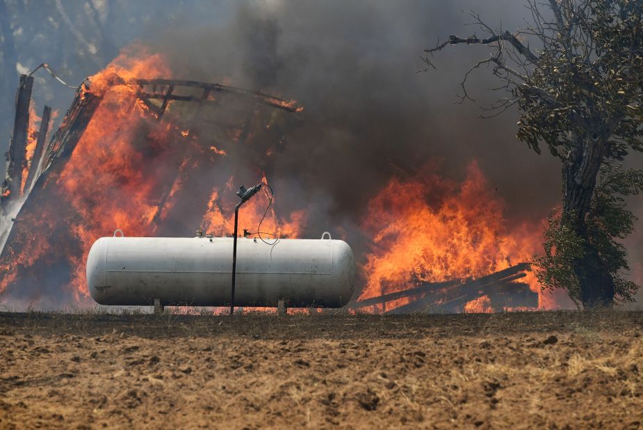 Flames approach a propane tank near the town of Lower Lake, California.  