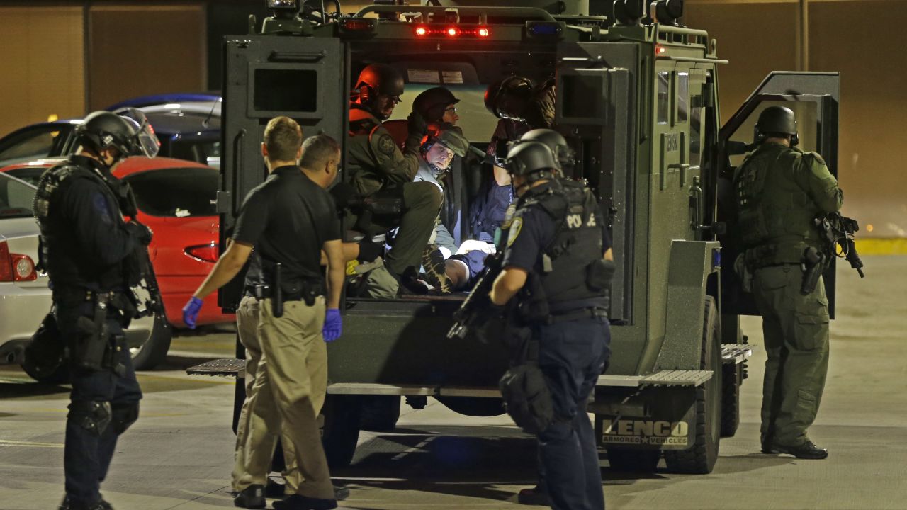 Police officers take an injured man in an armored vehicle to a hospital.