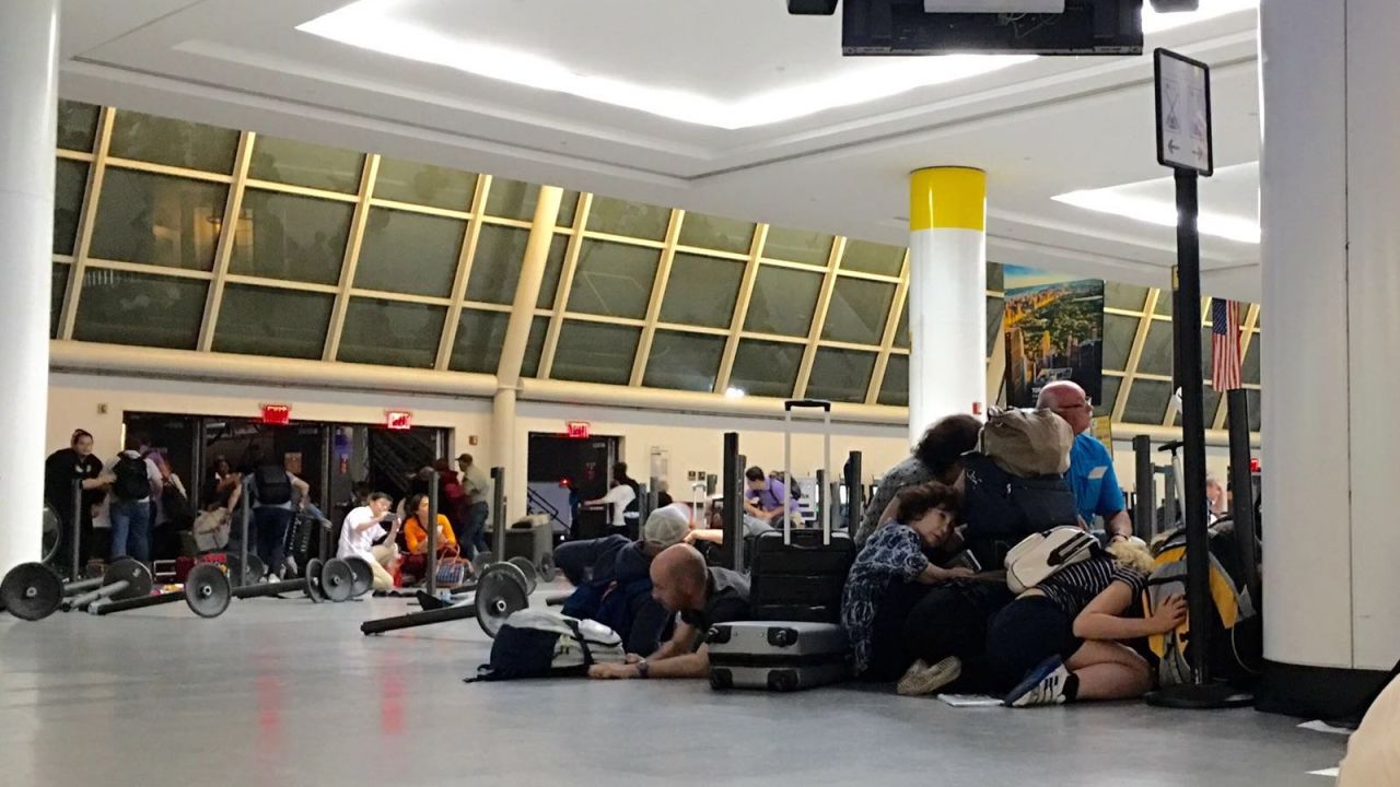 Passengers get down at the immigration control while police looking for an active shooter at JFK International airport in New York on August 14, 2016.
Unconfirmed reports of shots fired at New York's main airport triggered scenes of panic, massive evacuations and huge delays late Sunday. There was no immediate confirmation of injuries or arrests, but Port Authority police evacuated at least two terminals at John F. Kennedy International Airport out of precaution.
 / AFP PHOTO / Brigitte DUSSEAUBRIGITTE DUSSEAU/AFP/Getty Images