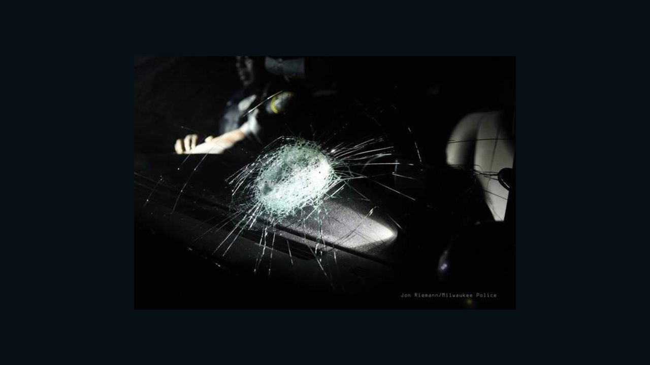 An officer was hospitalized after a rock broke the windshield of a police car.