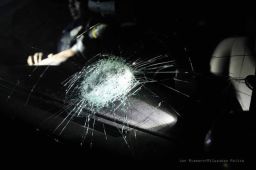 An officer was hospitalized after a rock broke the windshield of a police car.