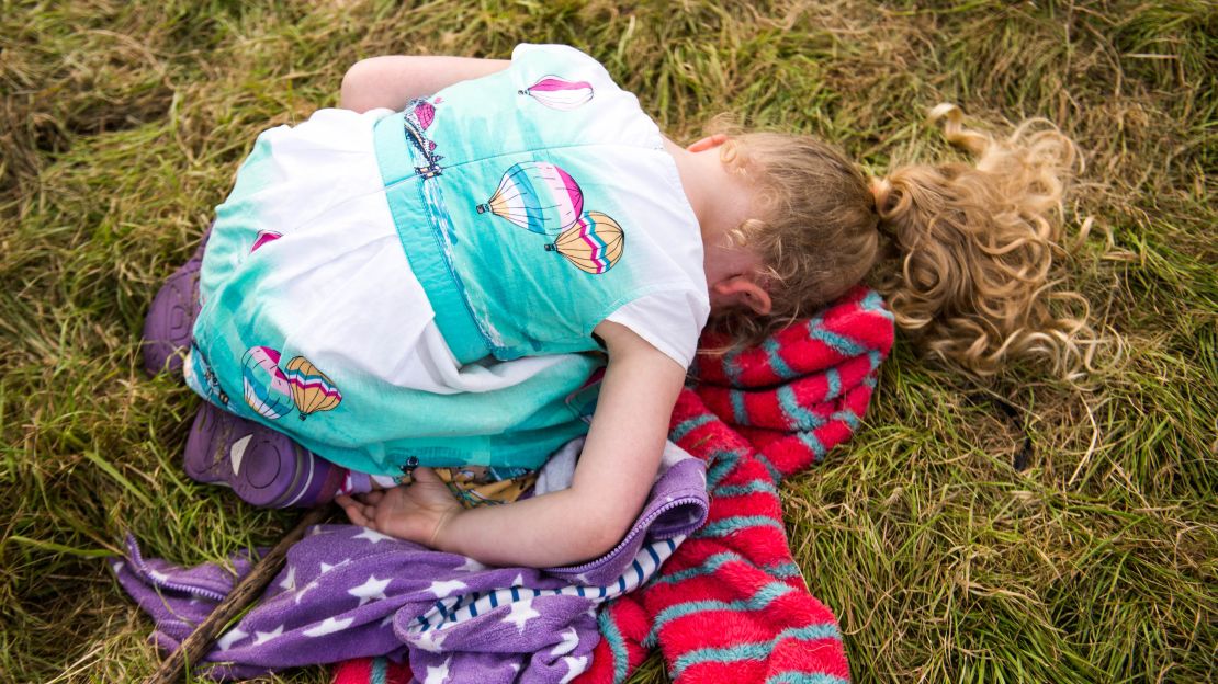 Four-year-old Pippa Robertshaw, wearing a balloon-print dress, buries her face while waiting for the mass lift to begin. 