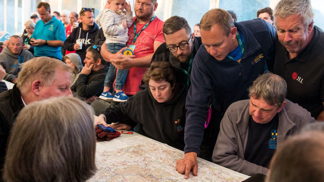 Pilots attend an early morning briefing on the final day of the fiesta. Before each launch, weather conditions are carefully assessed and crews informed about where they can and cannot land.