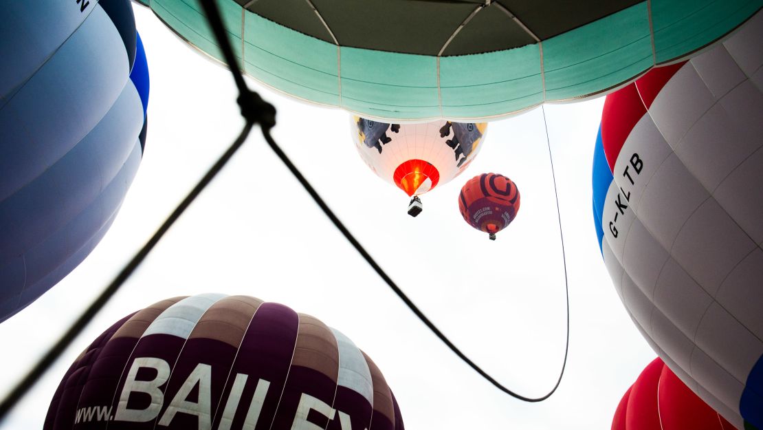 The pale green Fortnum & Mason balloon begins a careful ascent between other balloons during the mass lift on the final morning of the fiesta. 