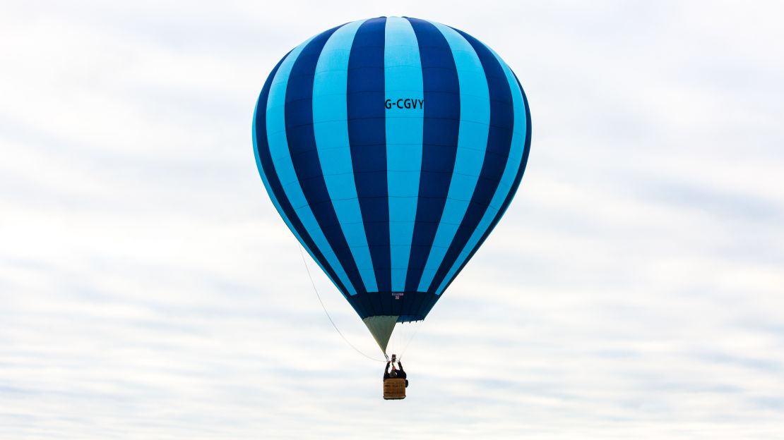 A lone balloon is seen floating in overcast skies. 