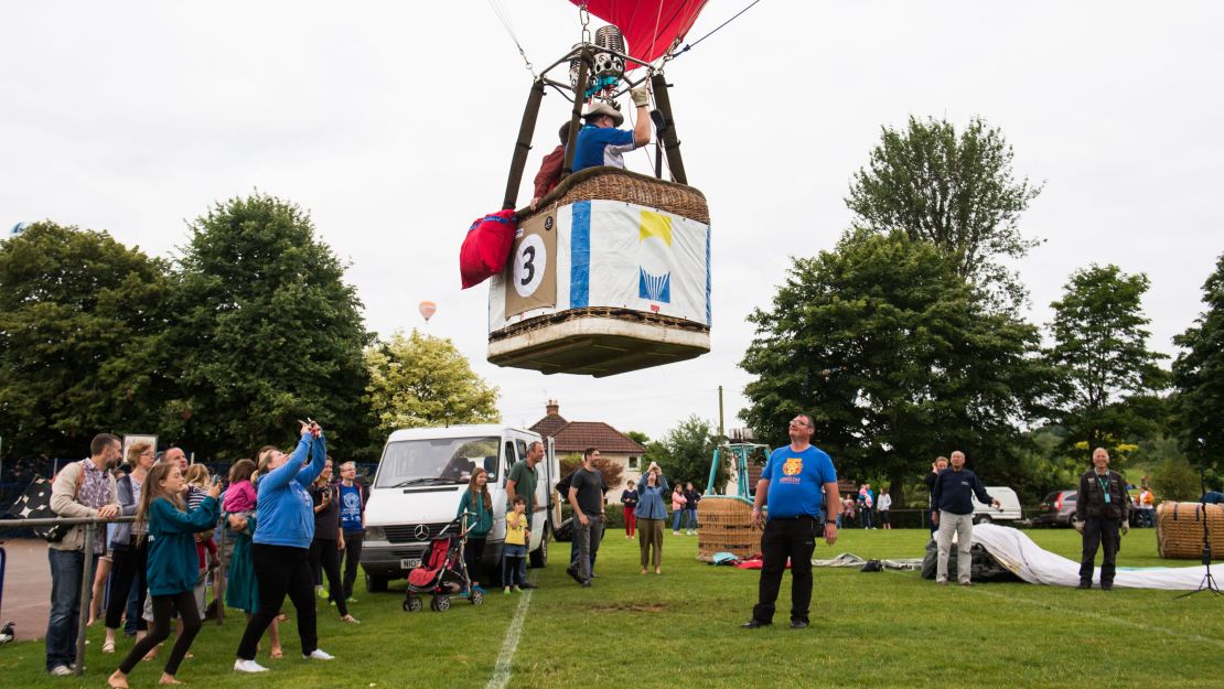 What goes up must come down: a balloon prepares to land on a recreation field in Long Ashton, where residents have gathered to watch.