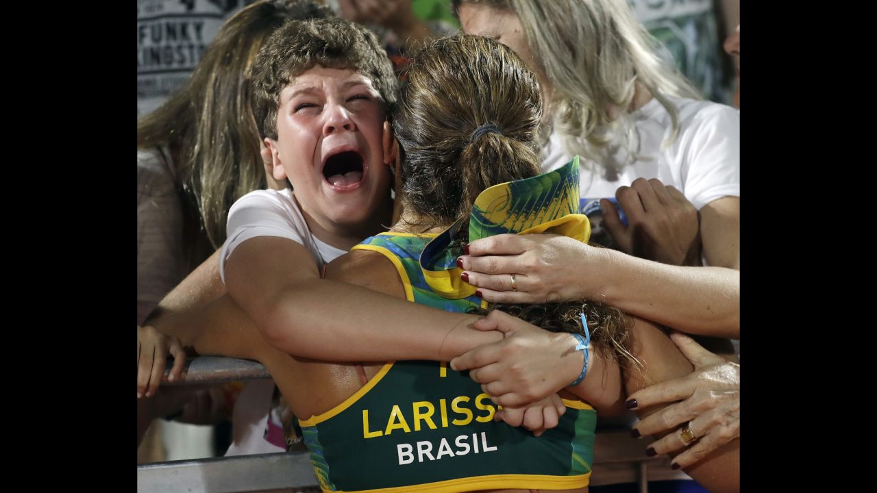 Larissa Franca, a beach volleyball player from Brazil, is hugged by supporters after a quarterfinal victory on Sunday, August 14.