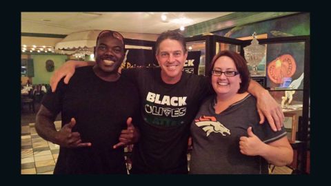 Restaurant owner Rick Camuglia, center, sports a "black olives matter" T-shirt in a photo with two customers.