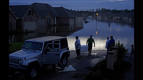 Residents evacuate Hammond, Louisiana, with food in ice chests on Saturday, August 13.