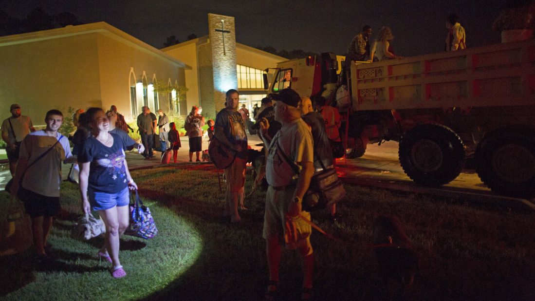 Those displaced by the flooding wait to board National Guard trucks at a Denham Springs church on August 14.