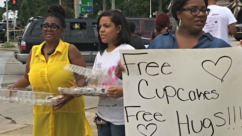 Valencia Morgan (far left) hands out cupcakes and hugs at the scene of last weekend's violent protests in Milwaukee.