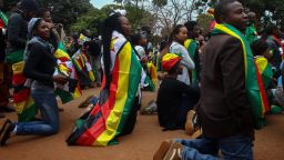 Supporters of "ThisFlag campaign" kneel for prayer at the entrance of the Harare magistrate's court where pastor Evan Mawarire appeared on charges of inciting public violence following his arrest ahead of a planned mass job stayaway on July 13, 2016. 
The pastor leading Zimbabwe's new protest movement walked free from court on July 13, 2016 after charges against him of attempting to overthrow President Robert Mugabe's authoritarian government were thrown out.  / AFP / Jekesai Njikizana        (Photo credit should read JEKESAI NJIKIZANA/AFP/Getty Images)