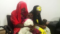Chibok girl Amina Ali Nkeki (in red), who was kidnapped by Boko Haram and escaped after two years, with her baby and friend Serah Luka.