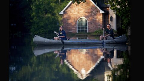 Danny and Alys Messenger canoe away from their flooded home in Prairieville on August 16.