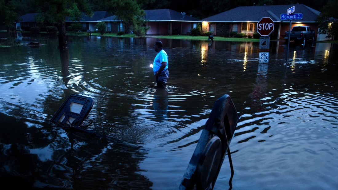 Tracy Thornton walks to his house through a flooded neighborhood in Baton Rouge on August 15.