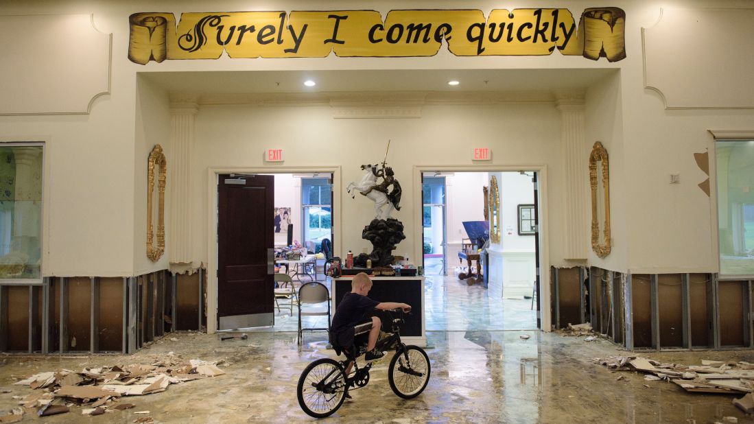 A boy in Baton Rouge rides his bike inside the flood-damaged Life Tabernacle Church on August 15.
