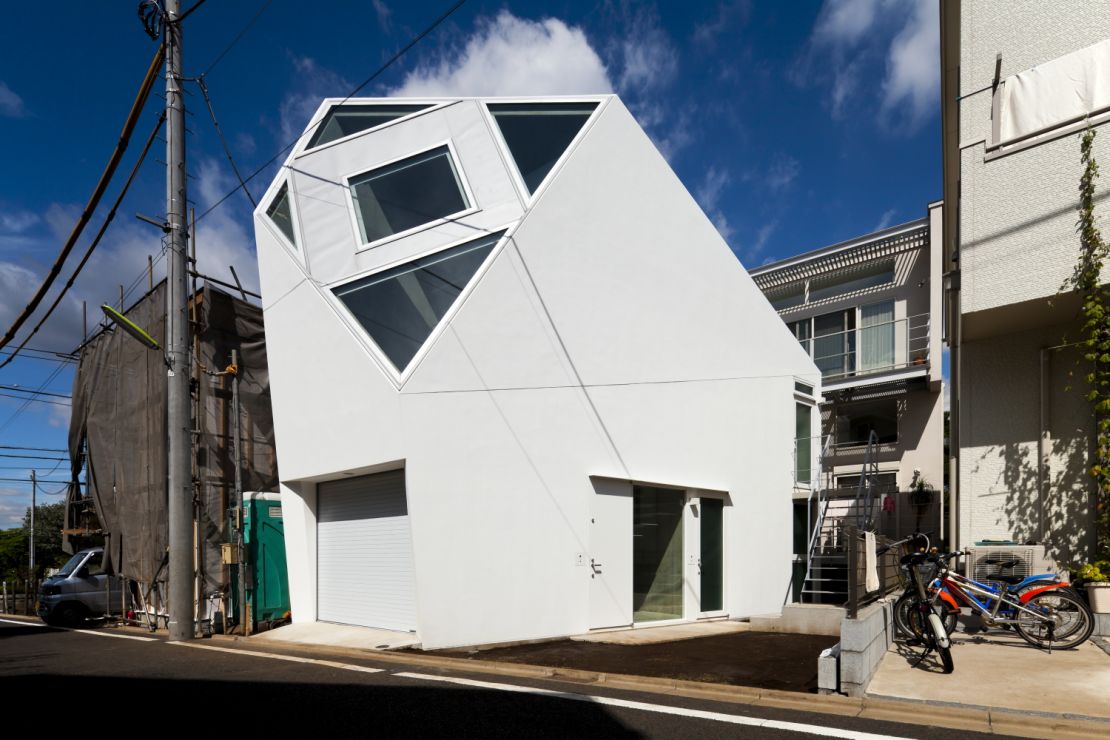 This Tokyo home, designed by Atelier Tekuto, takes the shape of a polyhedron in order to provide an enormous skylight above the living room.
