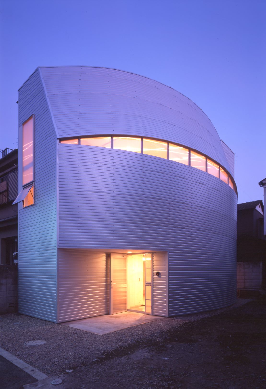 Designed by Atelier Tekuto for a family of five, Iron Mask is steel-based house with a unique curving facade that made the most of the site's shape.